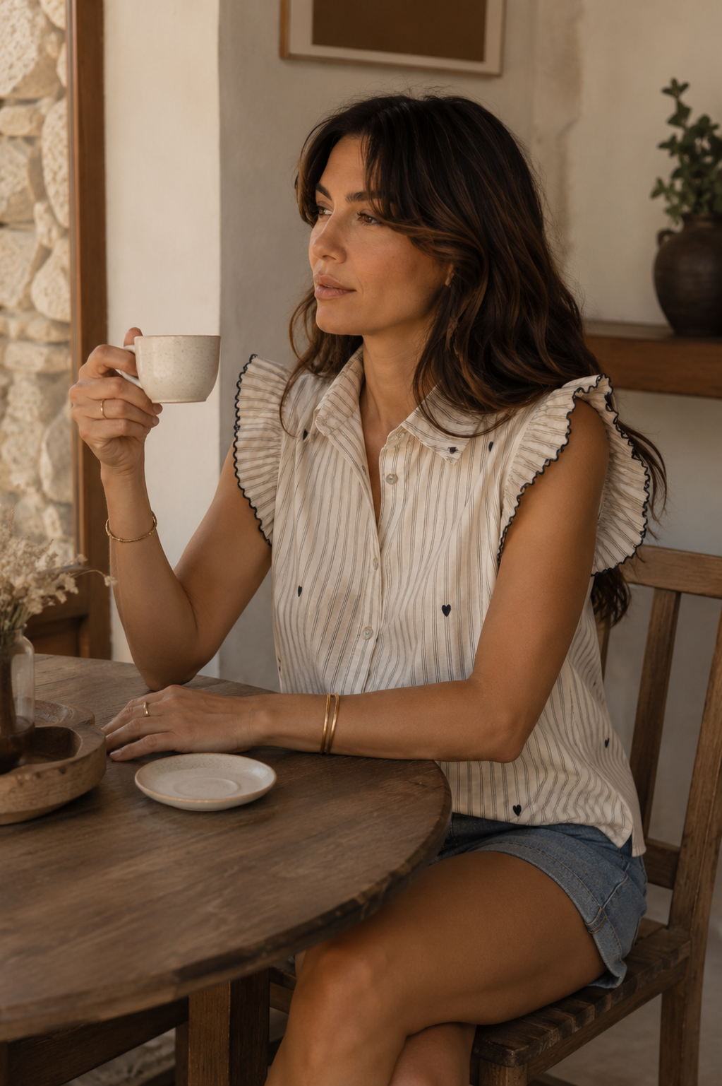 Blusa de algodón con rayas finas, pequeños corazones y mangas de volante, combinada con denim en un momento de estilo parisino relajado | STRANNA