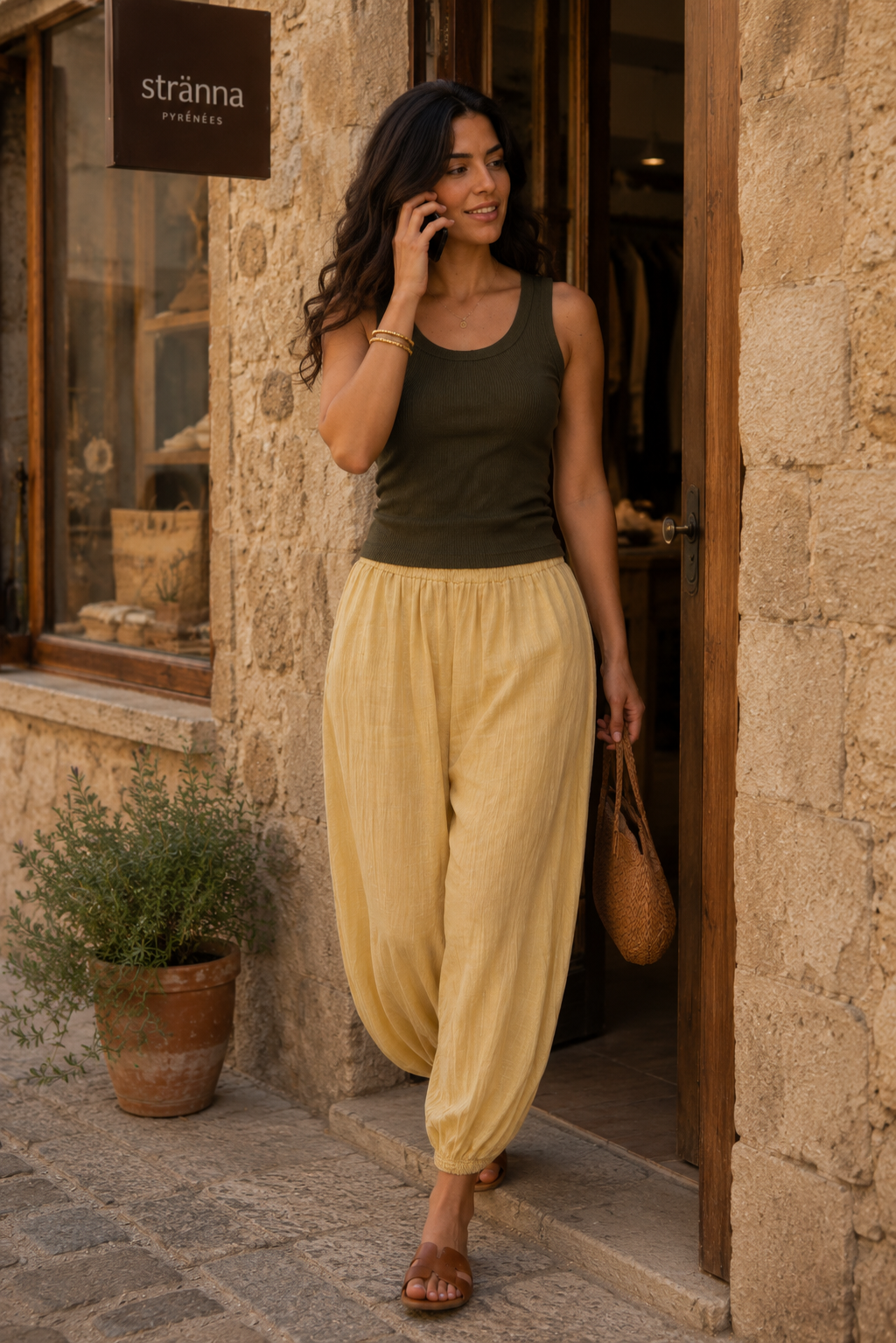 Pantalón bombacho amarillo vainilla de viscosa y lino con caída fluida, combinado con camiseta verde oliva y bolso trenzado en un outfit de verano elegante con estilo francés | STRANNA
