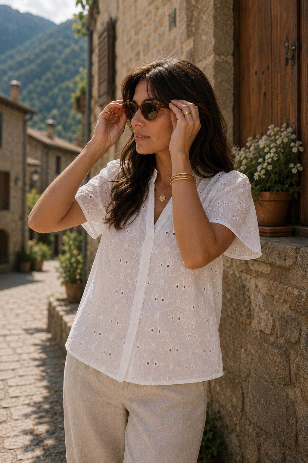Blusa blanca con bordados calados y cuello en V fruncido, combinada con pantalón beige y gafas de sol en un look de estilo francés | STRANNA